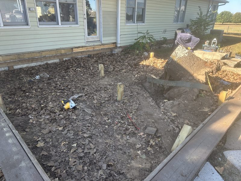 Deck torn out down to the dirt with the stump removed and new support posts set